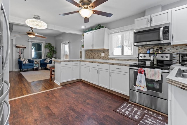 kitchen with stainless steel appliances, dark wood-type flooring, white cabinetry, light countertops, and decorative backsplash