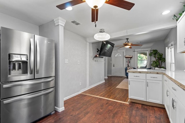 kitchen with dark wood-style floors, light countertops, white cabinetry, stainless steel fridge, and a peninsula