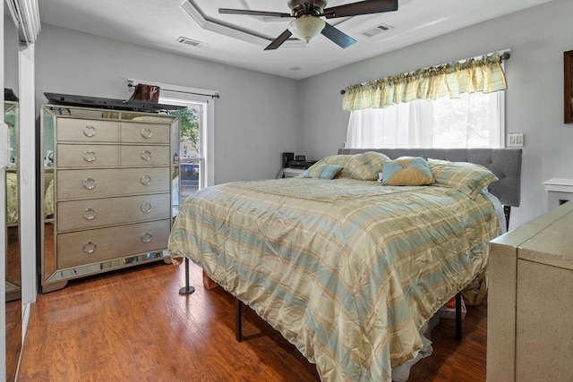 bedroom with dark wood-style flooring, visible vents, and ceiling fan