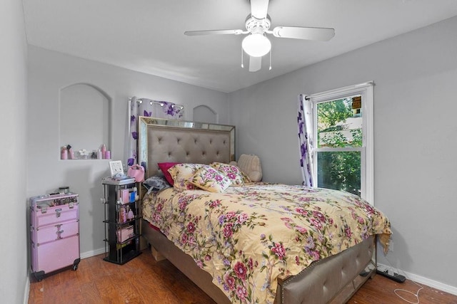 bedroom featuring dark wood-style floors, baseboards, and a ceiling fan