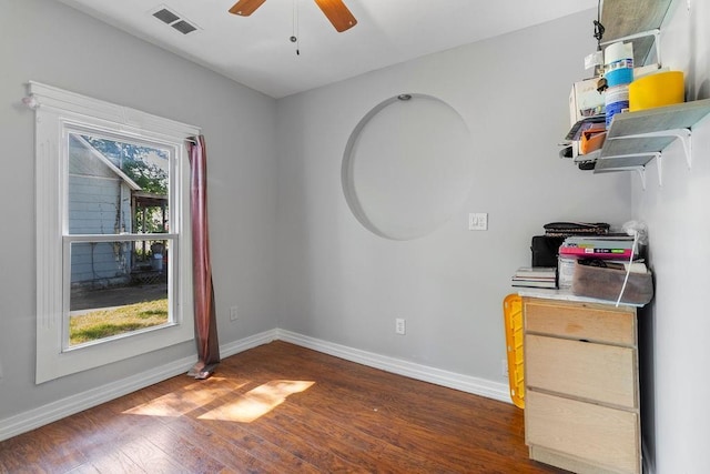 interior space featuring dark wood-style floors, baseboards, visible vents, and a wealth of natural light