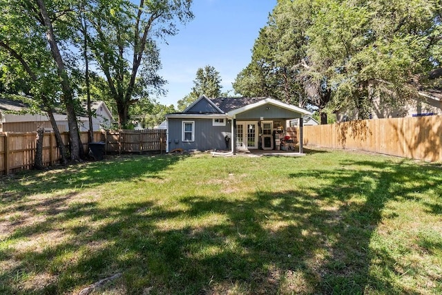 back of house with a fenced backyard, a patio, and a yard