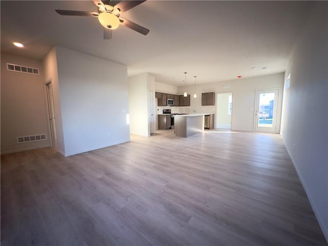 unfurnished living room with hardwood / wood-style floors and ceiling fan