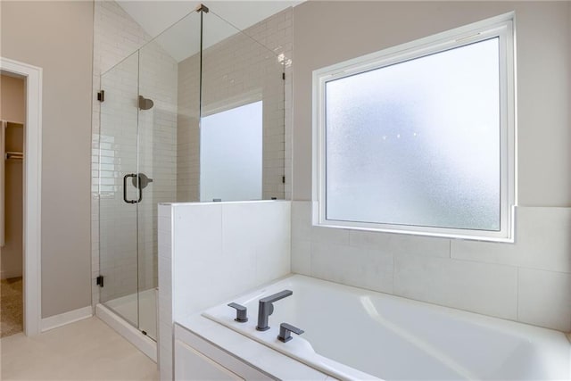 bathroom featuring separate shower and tub, lofted ceiling, and plenty of natural light