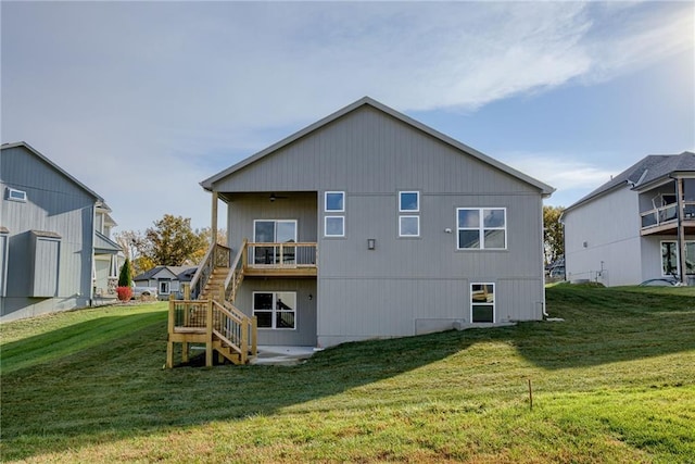 back of property with a balcony and a lawn