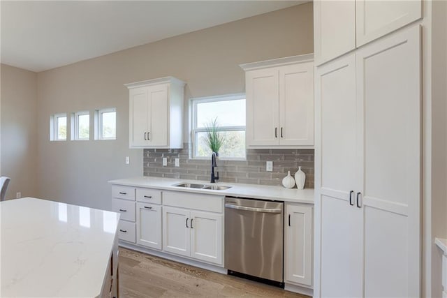 kitchen with decorative backsplash, dishwasher, light hardwood / wood-style flooring, sink, and white cabinetry