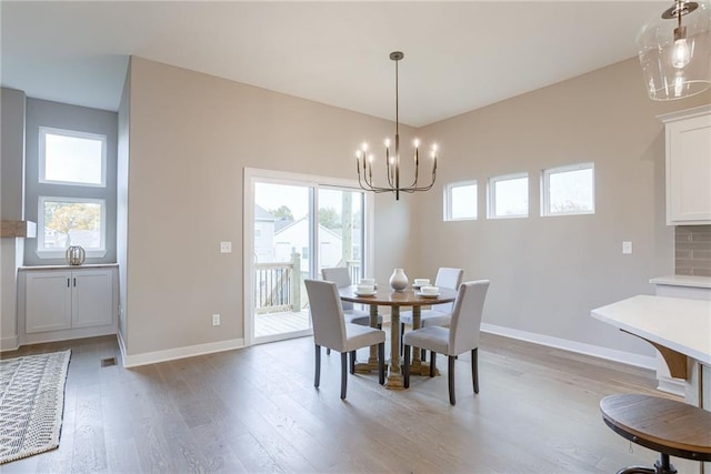 dining room with light hardwood / wood-style floors and a chandelier