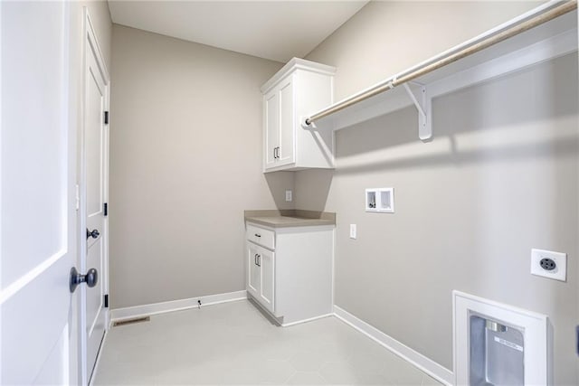 clothes washing area featuring cabinets, light tile patterned floors, washer hookup, and electric dryer hookup