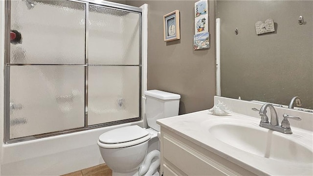 full bathroom with combined bath / shower with glass door, tile patterned floors, toilet, and vanity