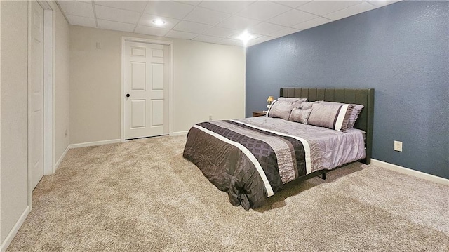 bedroom featuring light carpet and a paneled ceiling