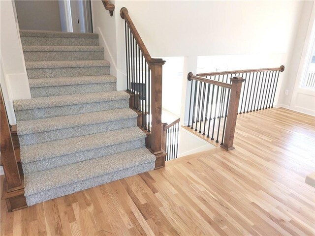 stairs featuring hardwood / wood-style floors