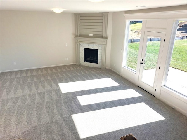 unfurnished living room featuring light carpet and a tile fireplace