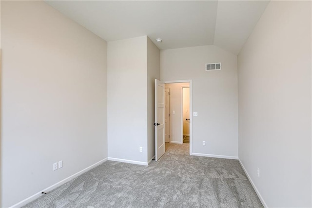 unfurnished bedroom featuring lofted ceiling and light colored carpet