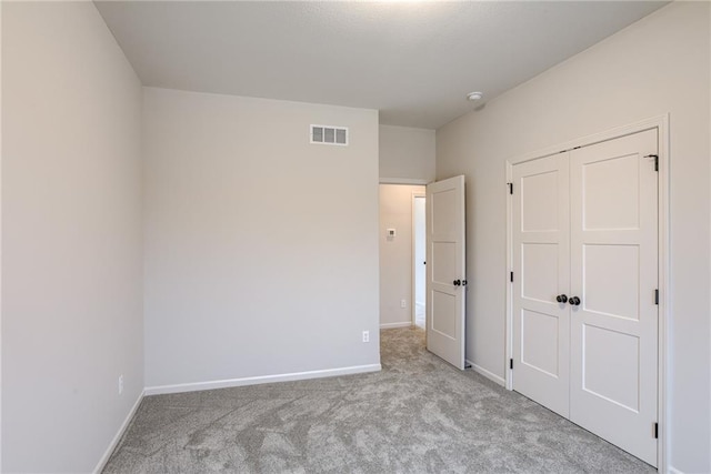 unfurnished bedroom featuring light carpet and a closet