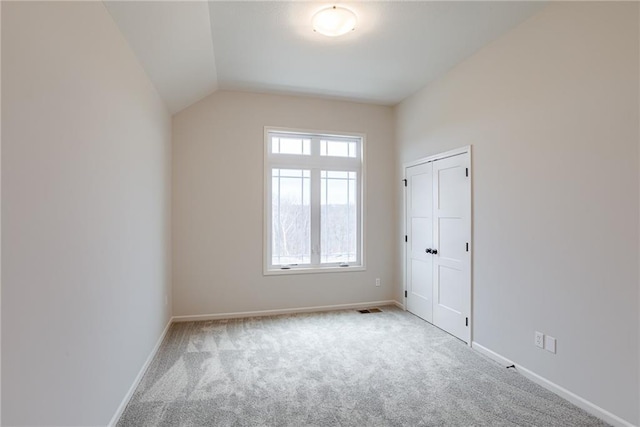 interior space with lofted ceiling and light colored carpet