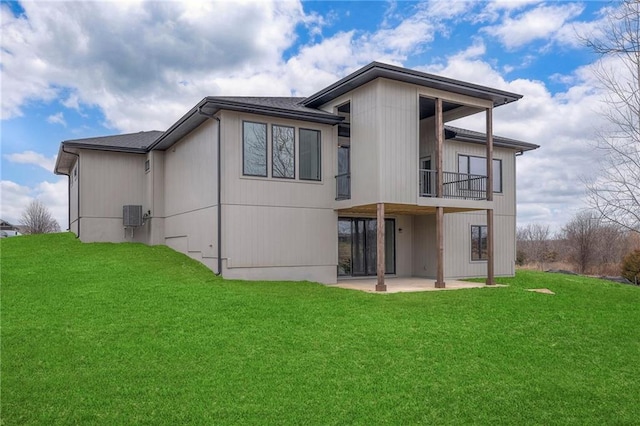 back of property with a lawn, a patio, and a balcony