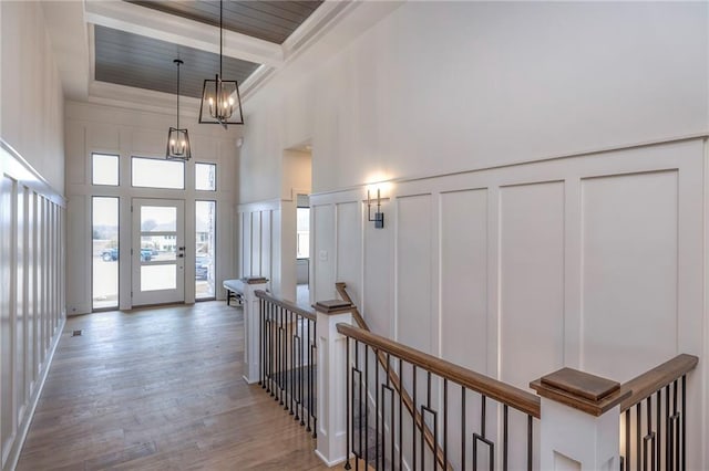 foyer entrance with beamed ceiling, a towering ceiling, hardwood / wood-style floors, and an inviting chandelier