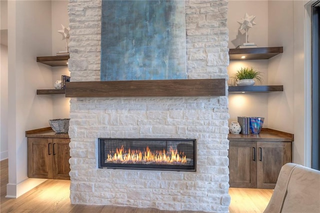 details featuring hardwood / wood-style flooring and a stone fireplace