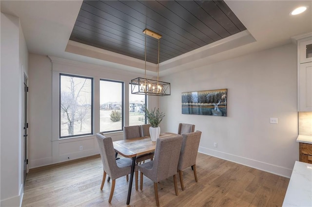 dining room featuring a chandelier, a raised ceiling, light hardwood / wood-style flooring, and wooden ceiling