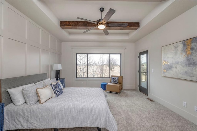 bedroom featuring ceiling fan, a raised ceiling, and light carpet