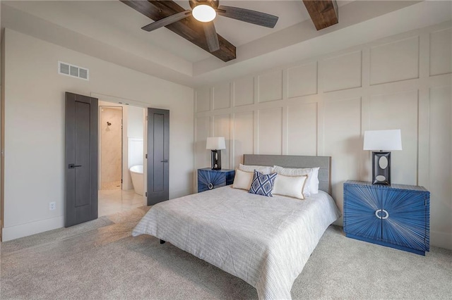 bedroom with beamed ceiling, ceiling fan, ensuite bathroom, and light carpet