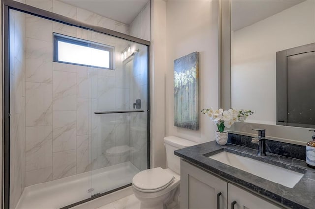 bathroom featuring vanity, toilet, and a shower with door