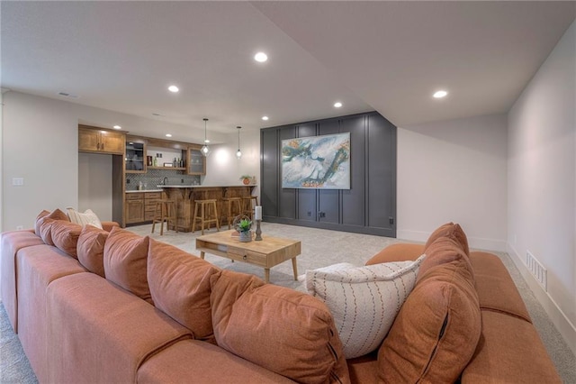 living room featuring indoor bar and light carpet