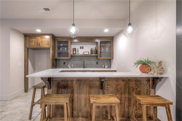 bar featuring tasteful backsplash, sink, and decorative light fixtures