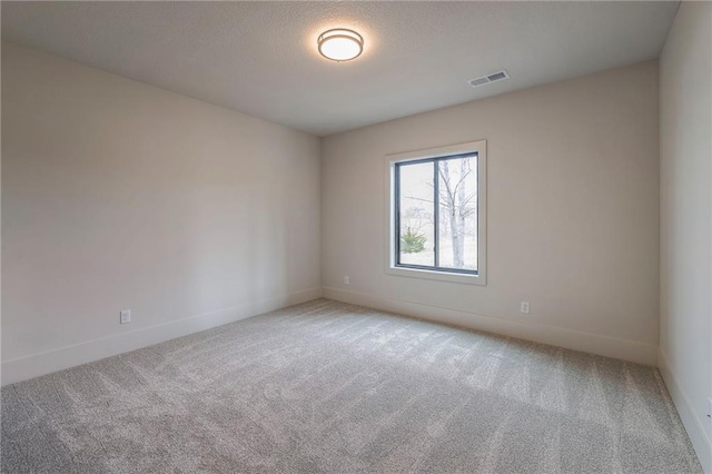 carpeted spare room featuring a textured ceiling