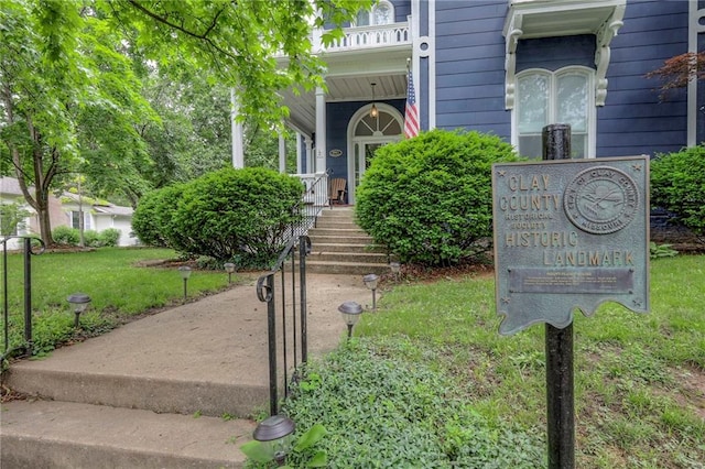 property entrance featuring a balcony and a yard