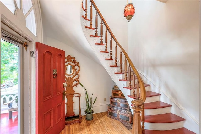 entrance foyer with stairs, wood finished floors, and baseboards