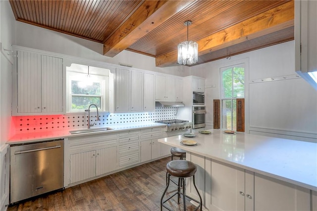 kitchen with decorative backsplash, light countertops, beamed ceiling, appliances with stainless steel finishes, and a sink