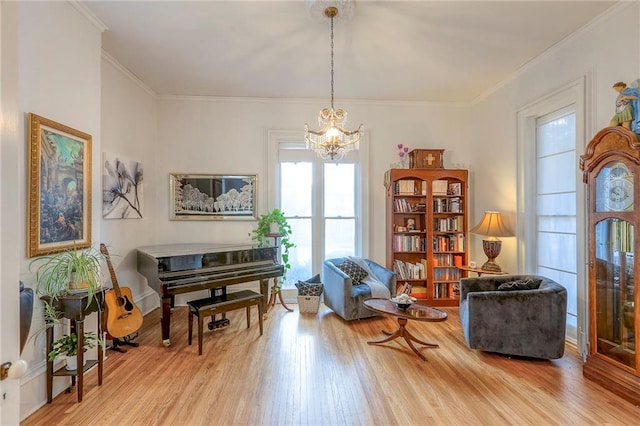 sitting room featuring wood finished floors, an inviting chandelier, and crown molding