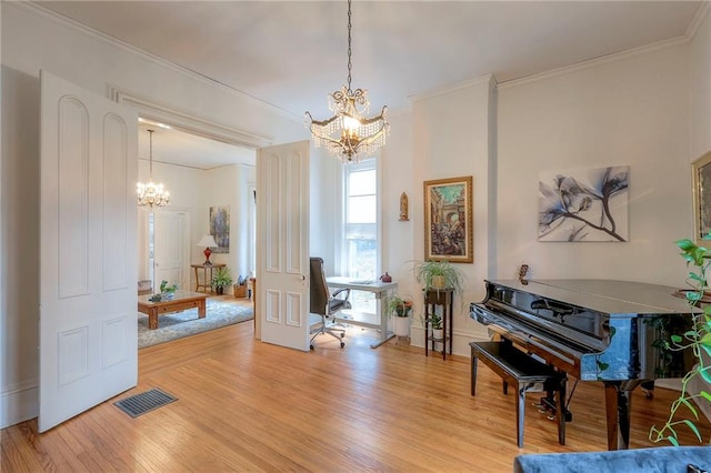 sitting room featuring visible vents, crown molding, wood finished floors, and a chandelier