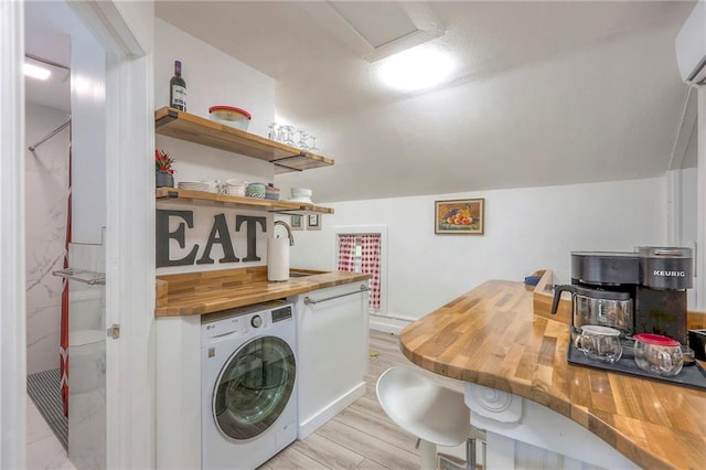 laundry room featuring light wood finished floors, washer / clothes dryer, laundry area, and a sink