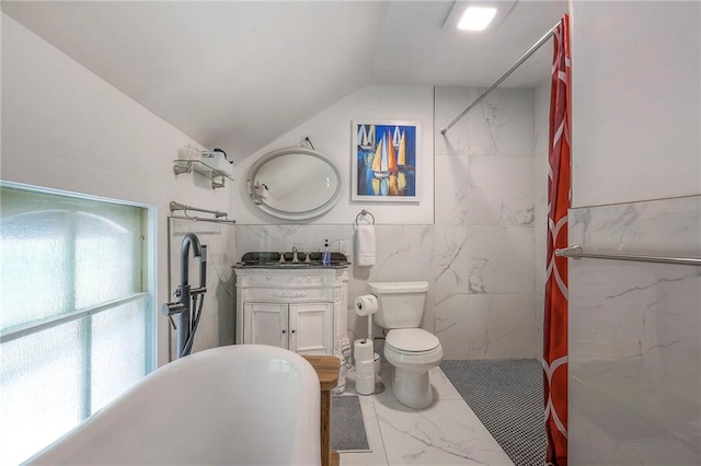full bathroom with vanity, a freestanding tub, vaulted ceiling, toilet, and marble finish floor