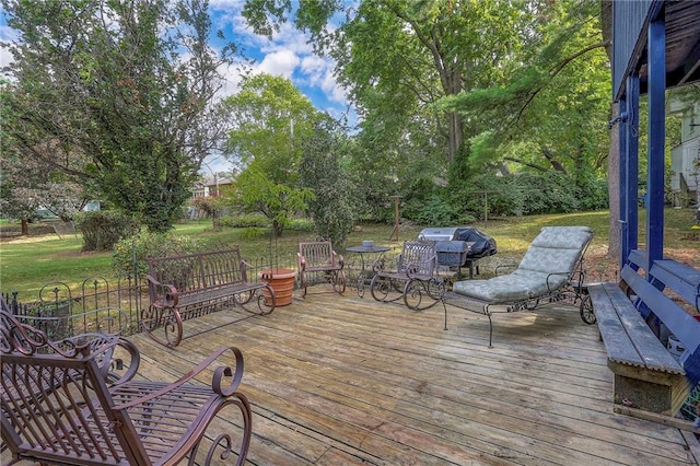 wooden deck featuring a grill and a yard