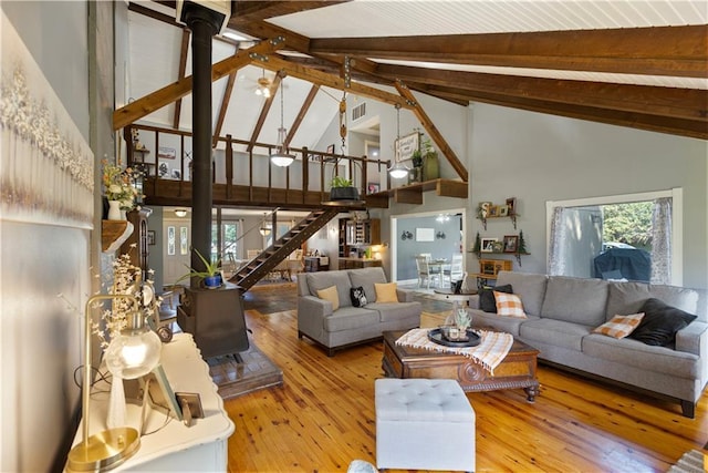 living room featuring hardwood / wood-style floors, beam ceiling, and high vaulted ceiling