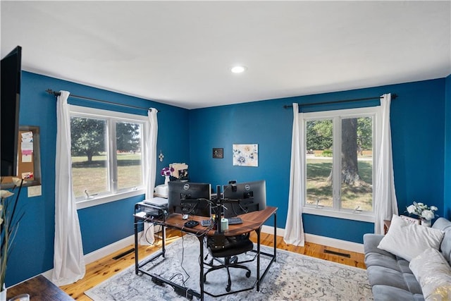 home office featuring hardwood / wood-style flooring and a healthy amount of sunlight