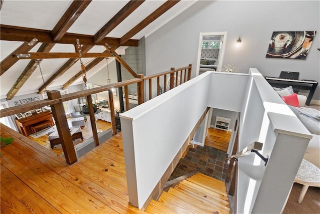 stairs featuring beamed ceiling and high vaulted ceiling