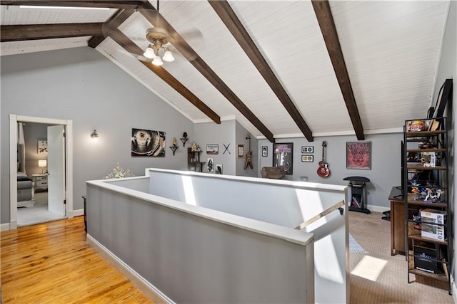 interior space with beamed ceiling, high vaulted ceiling, and light hardwood / wood-style flooring