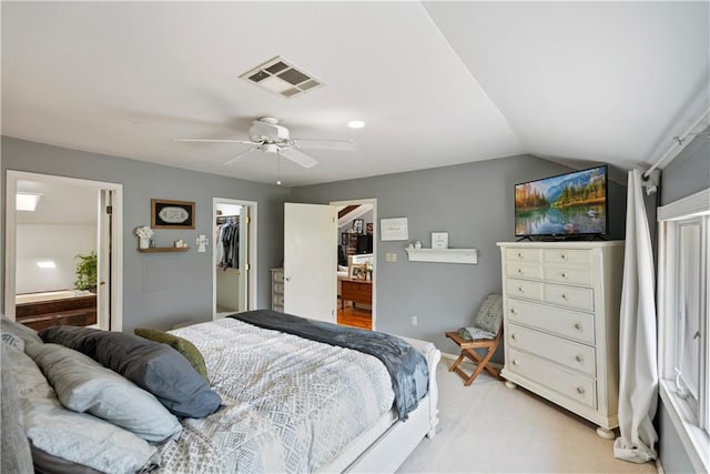 carpeted bedroom featuring lofted ceiling, connected bathroom, a spacious closet, a closet, and ceiling fan