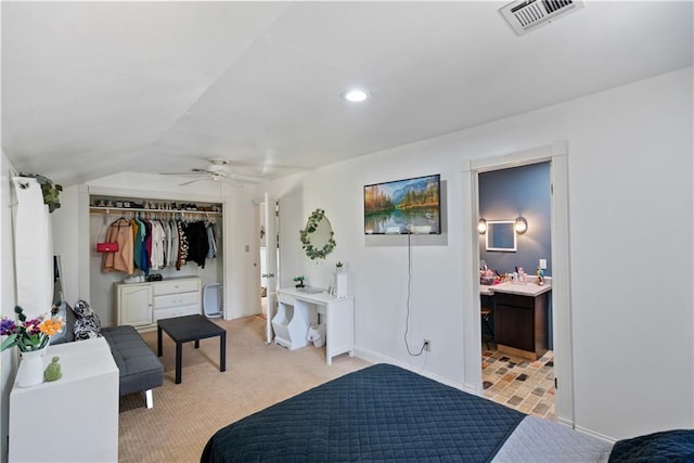 carpeted bedroom with ceiling fan, connected bathroom, vaulted ceiling, and a closet