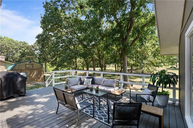 deck with grilling area, an outdoor hangout area, and a storage unit