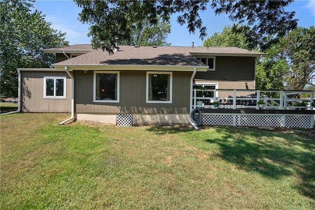 back of house featuring a wooden deck and a lawn