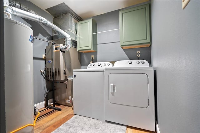2924 Crown Dr, Independence, KS 67301 - washroom with cabinet space, independent washer and dryer, light wood-style flooring, and water heater