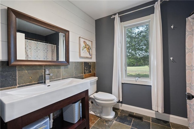 2924 Crown Dr, Independence, KS 67301 - full bath with vanity, stone finish flooring, backsplash, and tile walls