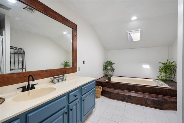 2924 Crown Dr, Independence, KS 67301 - bathroom with lofted ceiling, vanity, a bath, a skylight, and recessed lighting