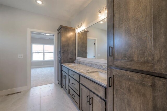 bathroom featuring double vanity, baseboards, a sink, and recessed lighting