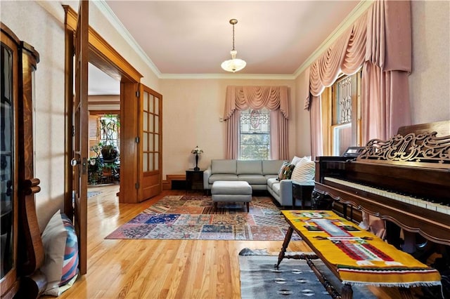 living area featuring hardwood / wood-style flooring, crown molding, and plenty of natural light